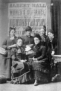 Undated. View shows six women in Victorian period dress from the suffrage movement in front of a poster declaring: 'Albert Hall, Sheffield, Women's Suffrage, Great Demonstration of Women'. Lady seated front right maybe Alice Cliff Scatcherd. Courtesy of www.leodis.net